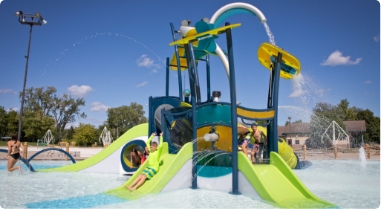 children playing on splash pad playground equipment