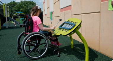 girl in wheelchair playing on outdoor metallophone