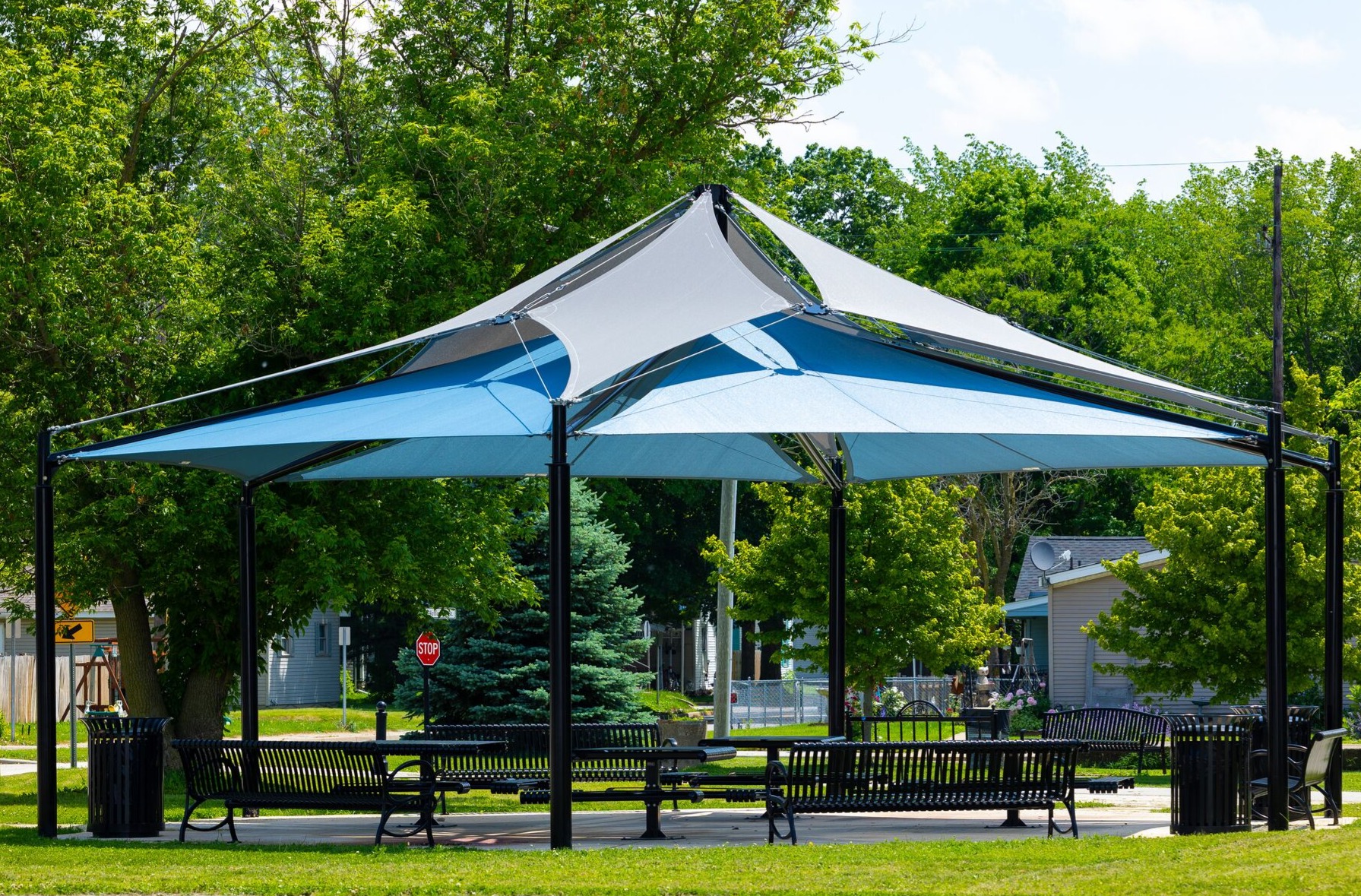 Double layer blue and grey hexagon shade over picnic tables and benches